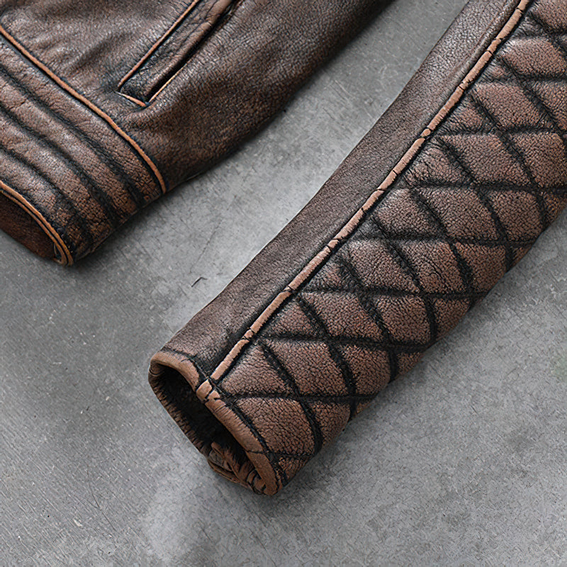 Close-up of vintage brown leather motorcycle jacket sleeve with quilted design and stylish stitching details.