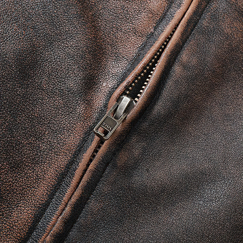 Close-up of vintage brown genuine leather motorcycle jacket zipper detail highlighting quality craftsmanship.