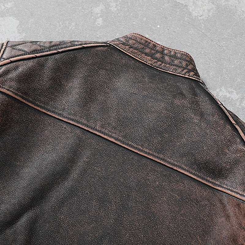 Close-up of vintage brown genuine leather motorcycle jacket showcasing the textured back design and stitching details.