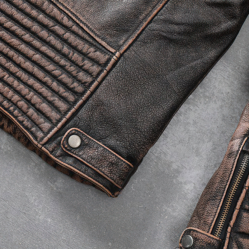 Close-up of vintage brown genuine leather motorcycle jacket with detailed stitching and zipper.