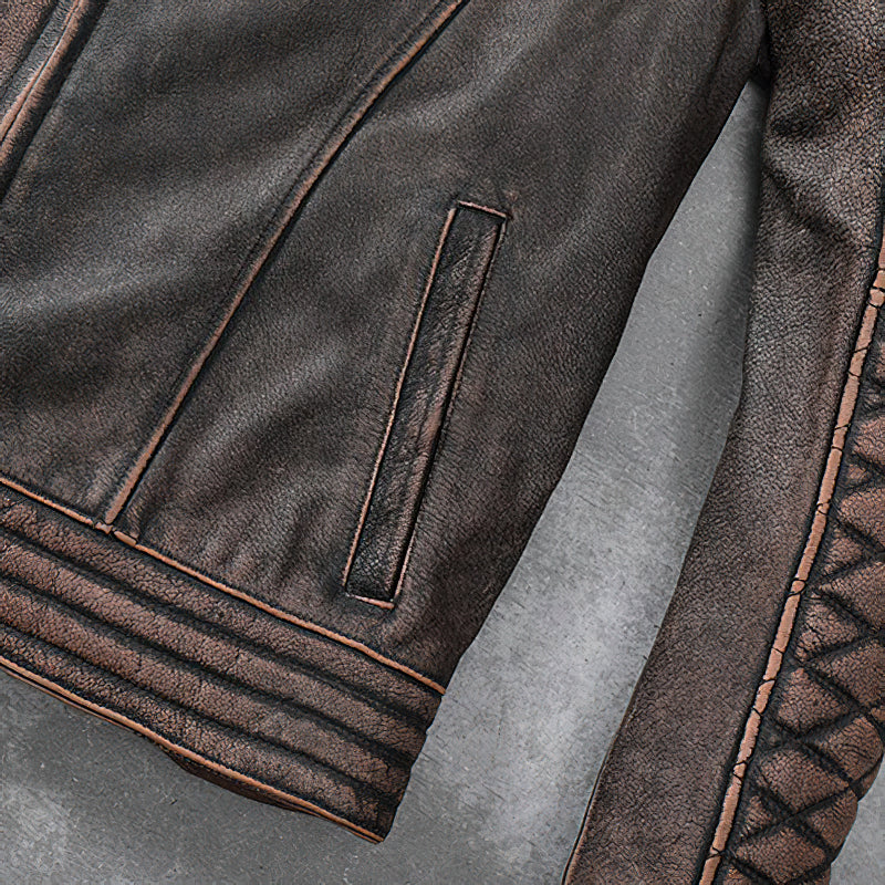 Close-up of vintage brown genuine leather motorcycle jacket with stylish stitching and pocket detail.