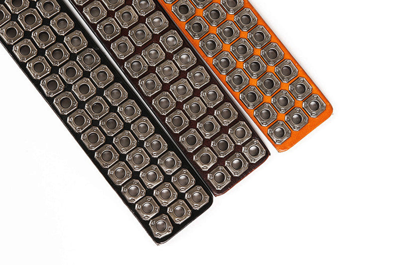 Heavy metal cowboy belts in black, brown, and orange with decorative rivets for a stylish western look.