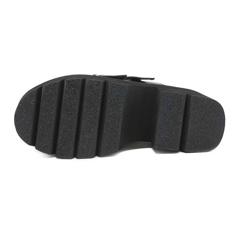 Bottom view of black chunky platform sandals, showcasing textured sole for stability and comfort.