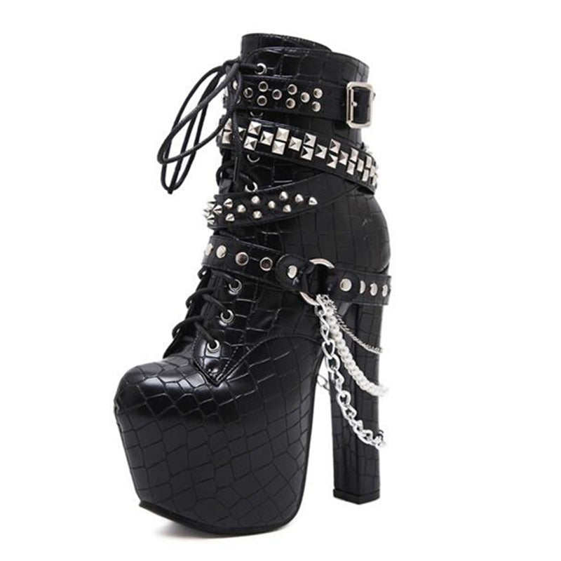 Gothic women's ankle platform boots with chains and rivets. Stylish black patent leather high heels for bold fashion.