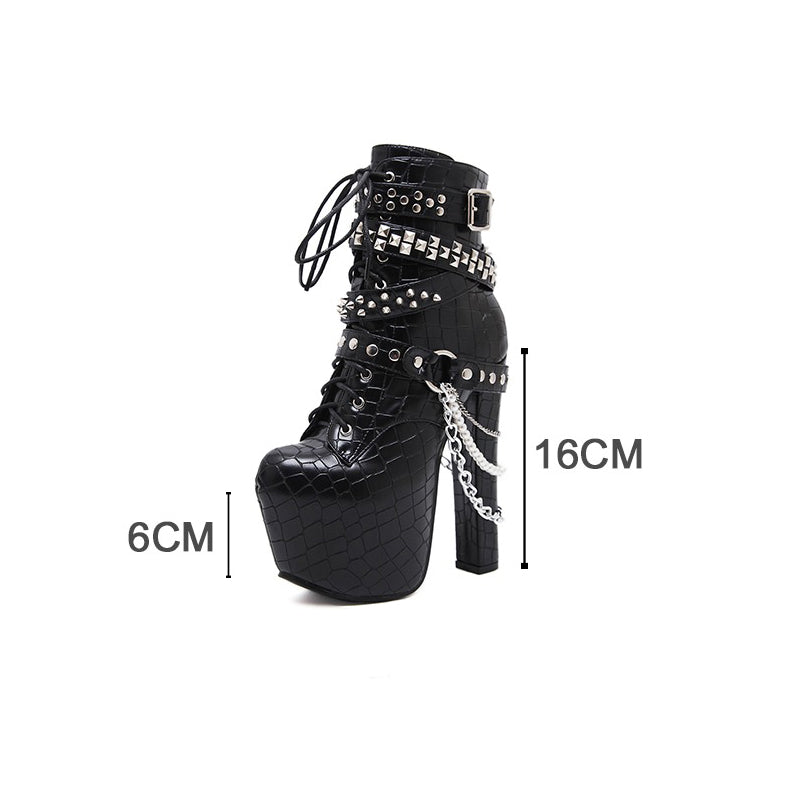 Black Gothic ankle boots with high platform, chains, and studs, featuring a sleek patent leather look.
