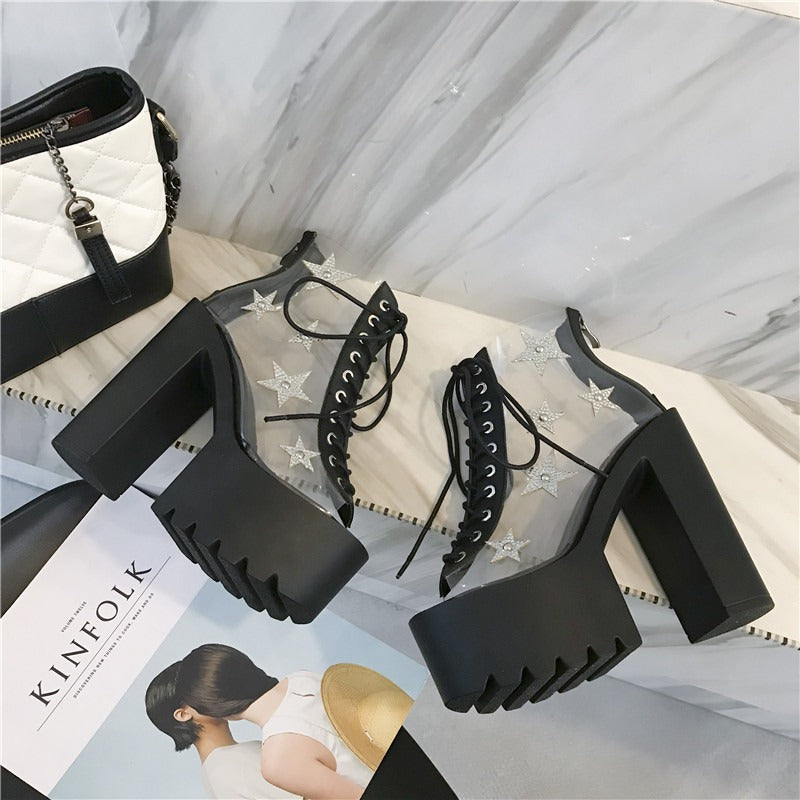 Punk style high heels sandals with PVC panels and star details, featuring lace-up design and chunky platform.