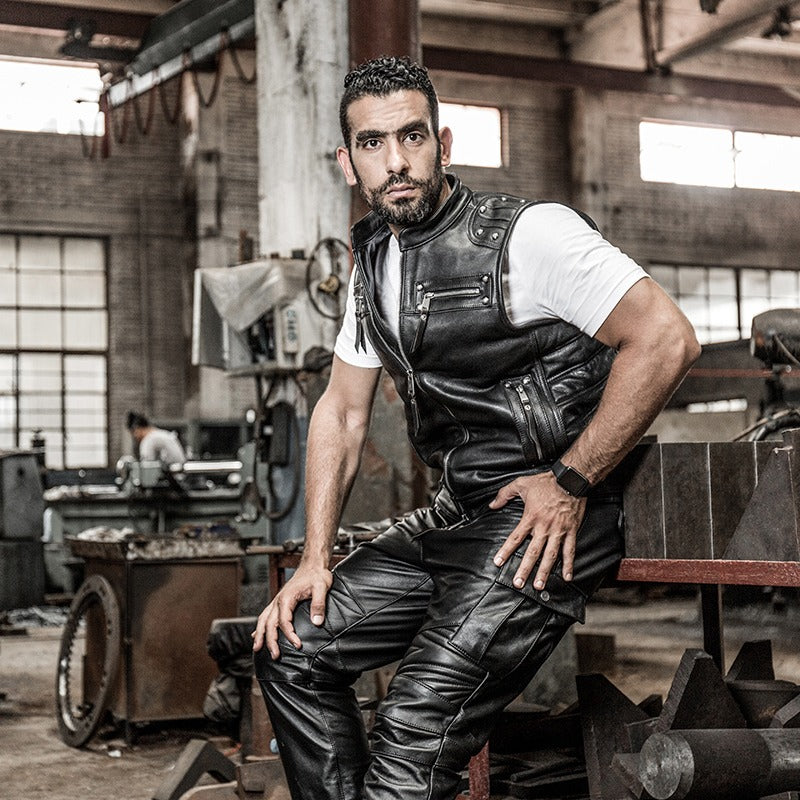 Stylish man in a sleeveless genuine leather biker vest, exuding cool biker fashion in an industrial setting.