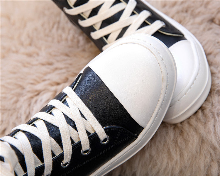 Close-up of stylish black and white high top sneakers with laces, perfect for retro rock lovers.