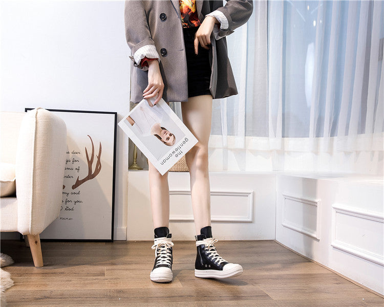 Female model showcasing high top retro rock platform sneakers in a stylish living room setting.