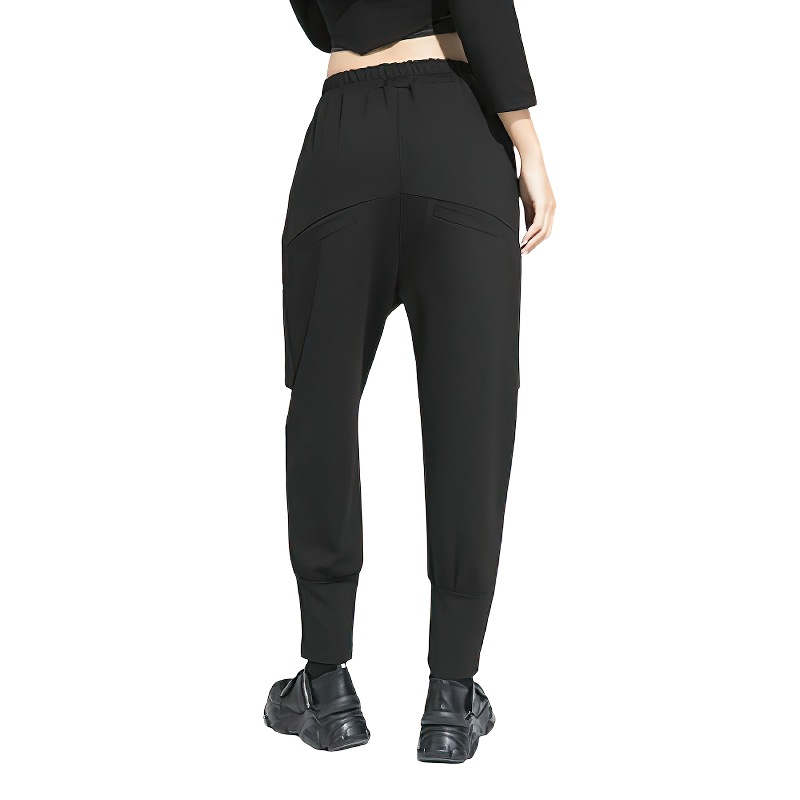 Back view of stylish high waist black alternative women's harem pants with pockets and elastic waist.