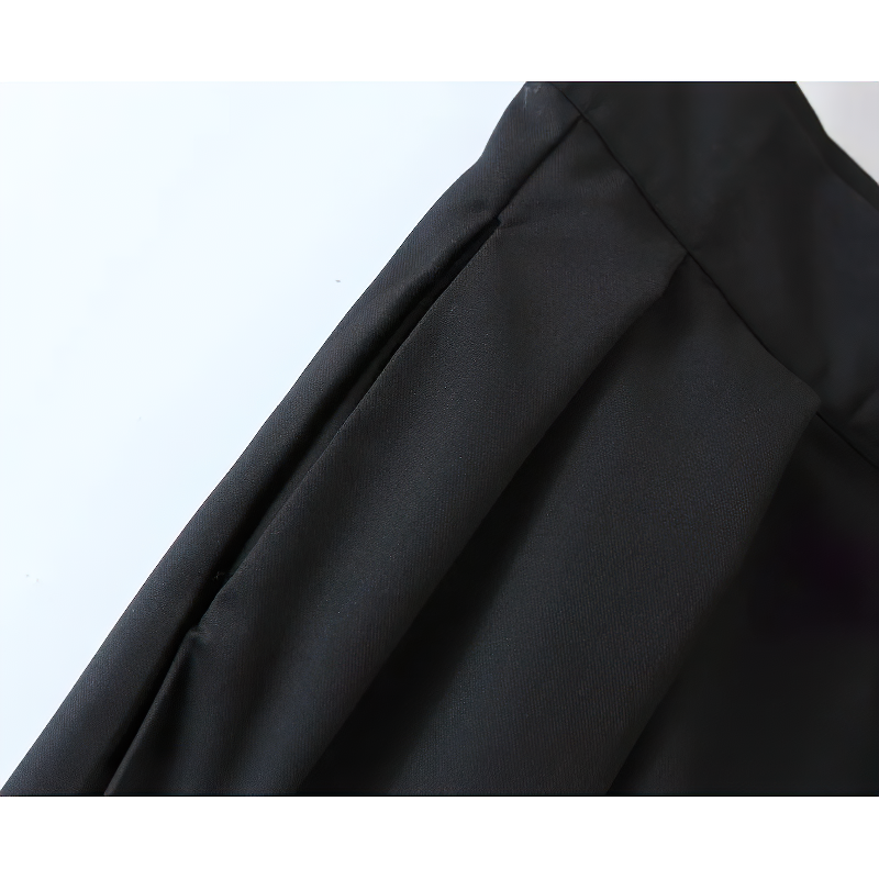Close-up of high waist black pleated women's pants showcasing fabric texture and elegant pleat details.