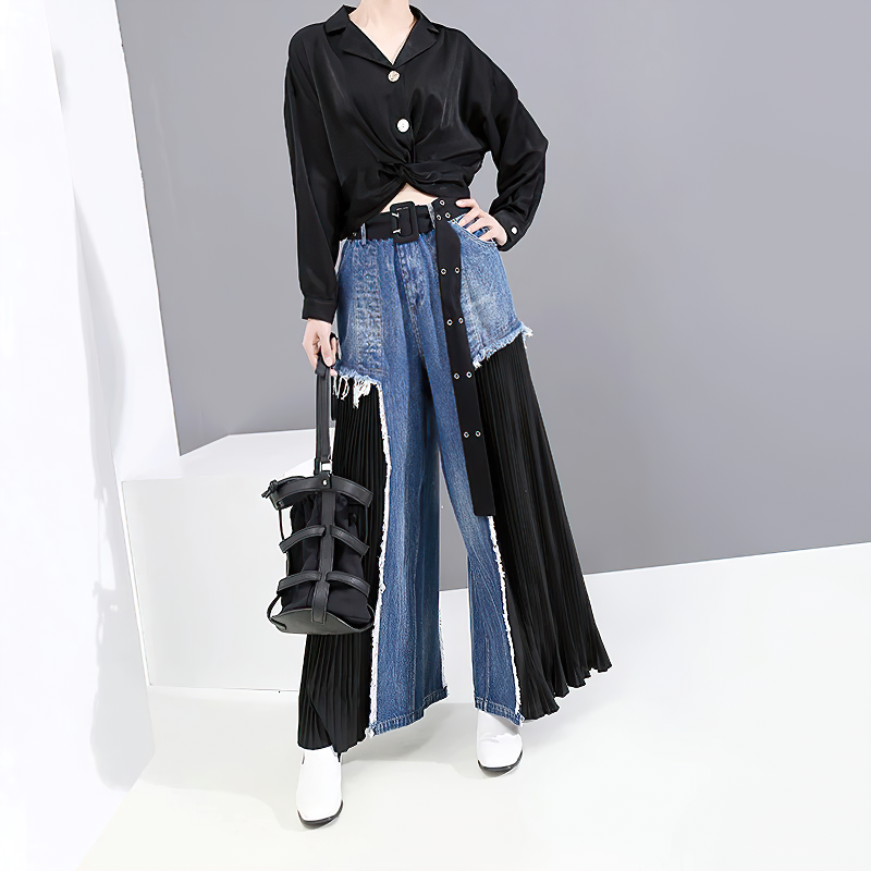 Stylish woman wears high waist blue denim trousers paired with a black top, showcasing a trendy alternative look.