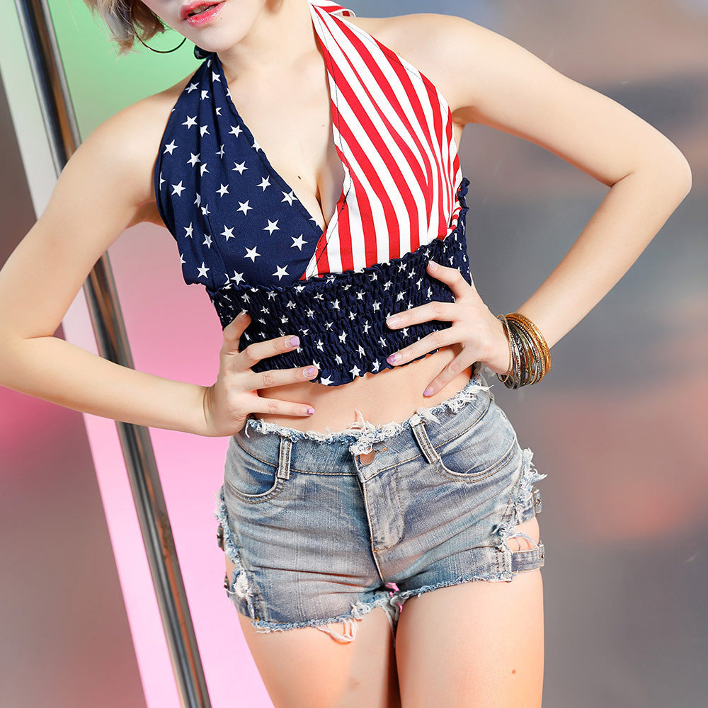 Stylish woman in a halter top with American flag design and distressed high waist denim shorts, exuding rocker chic vibes.