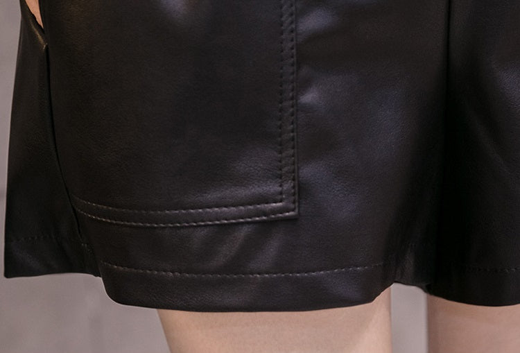 Close-up of women's high waist faux leather shorts showcasing solid pockets and sleek, wide-leg design.