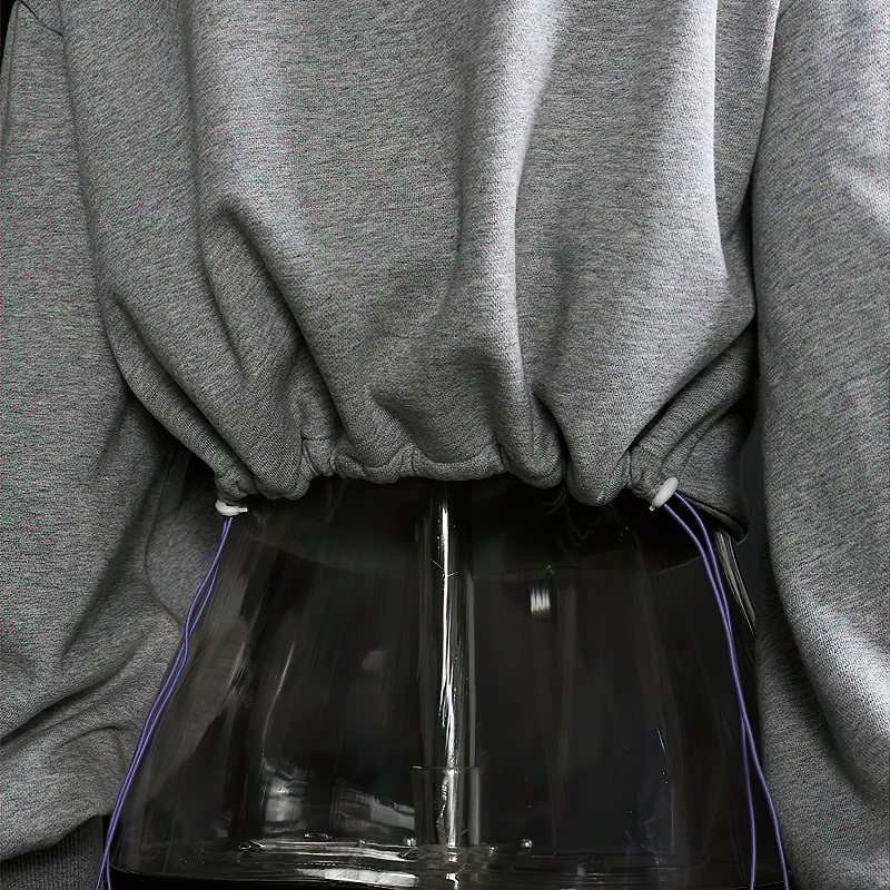 Close-up of hollow out hooded grey female long sleeve top showcasing laces, perfect for alternative streetwear style.