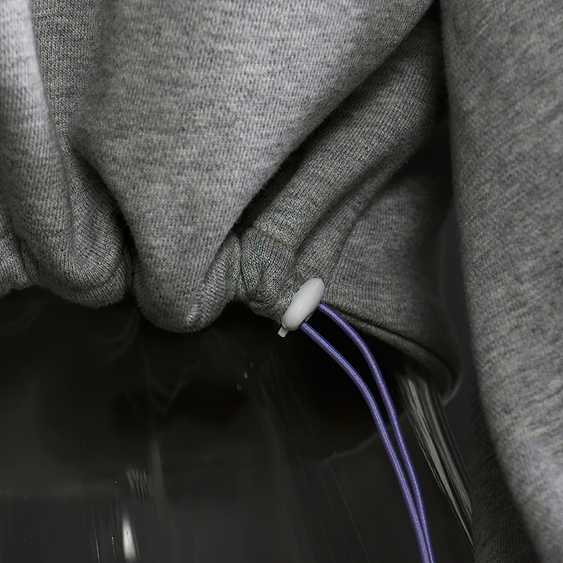 Close-up of the grey hollow out hooded top showing laces and adjustable drawstring detail.