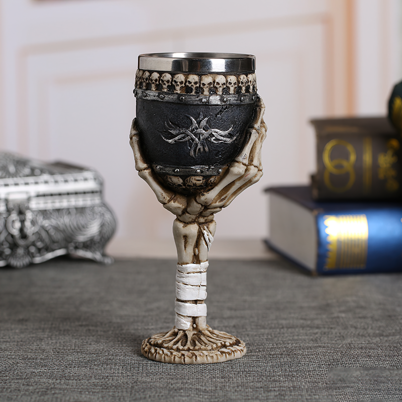 Vintage gothic wine glass with skulls and skeletal arm, perfect for dark themed decor and unique gifting.