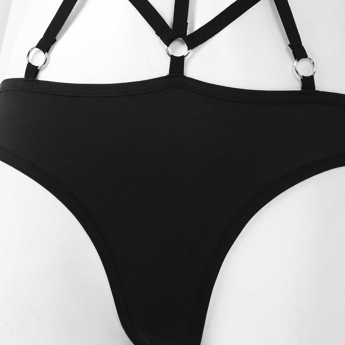 Close-up of a black women's monokini swimsuit with stylish straps and ring details, perfect for beach or pole dance.