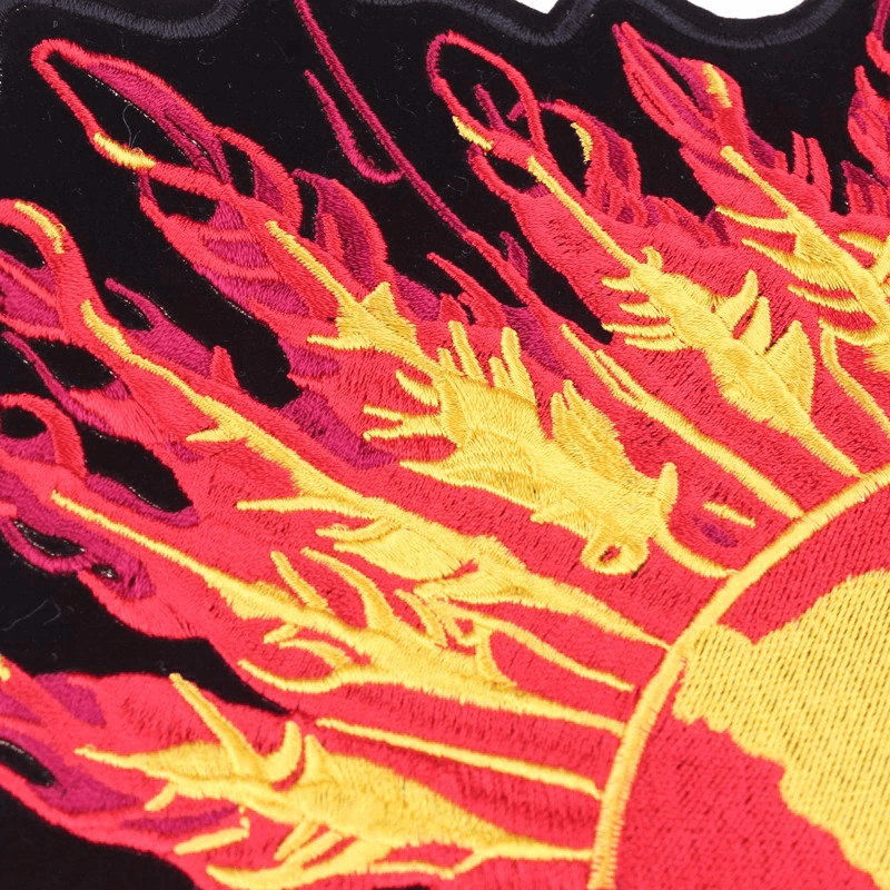 Close-up of a vibrant embroidered sun patch with flames for biker jackets and accessories.