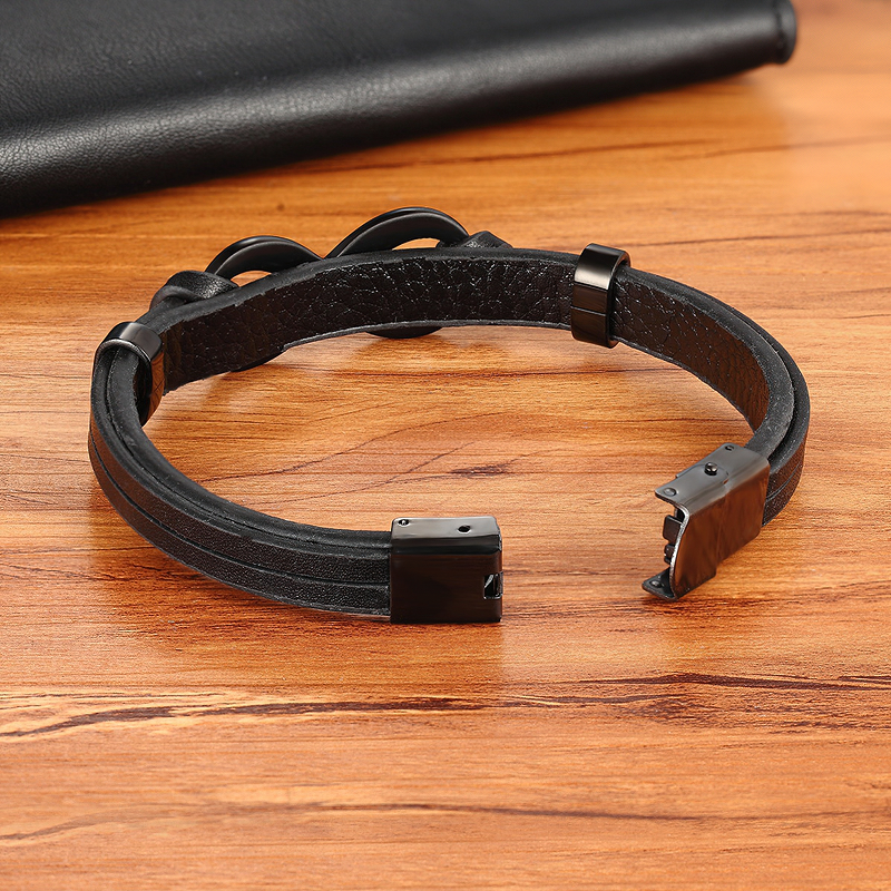 Stylish infinity logo stainless steel leather bracelet on wooden surface, perfect for vintage fashion lovers.