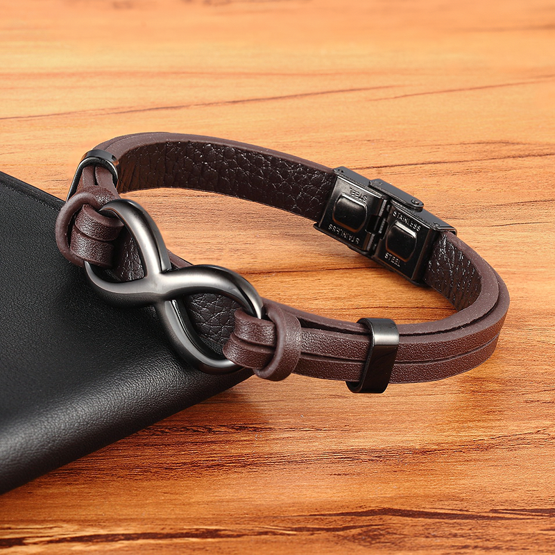 Infinity logo stainless steel leather bracelet on wooden table, perfect for vintage style outfits.