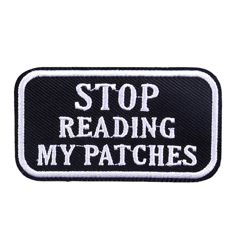 Black iron-on patch with white text saying 'STOP READING MY PATCHES' - a trendy rock style accessory.
