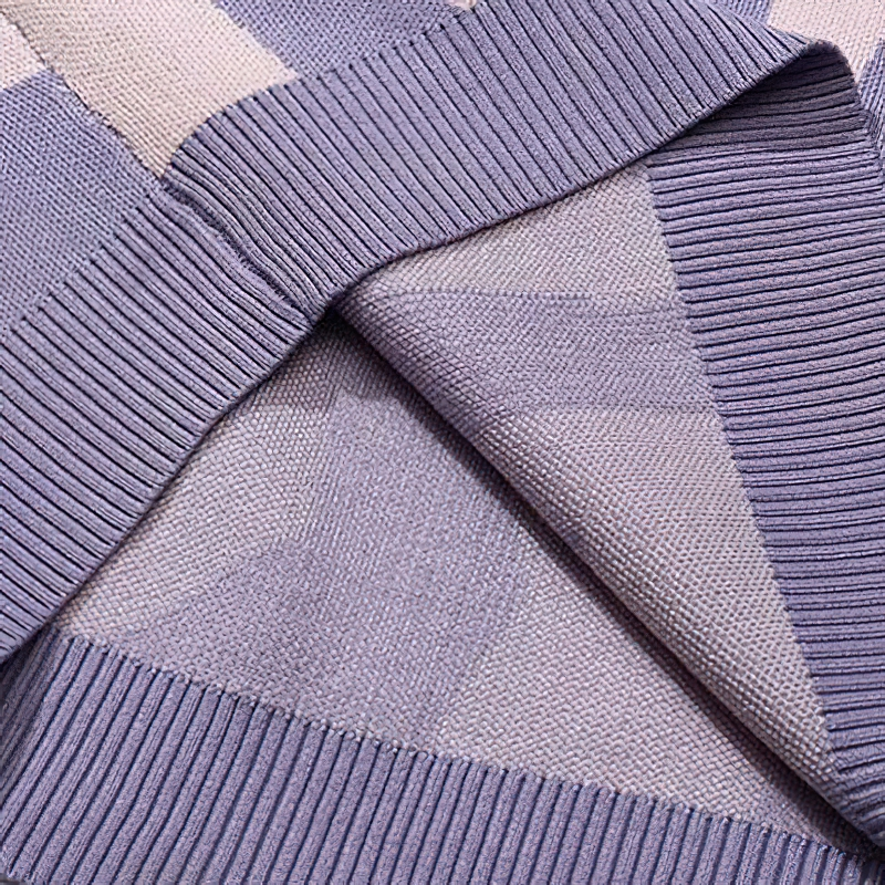 Close-up of soft textured knitted fabric showcasing purple hues and ribbed detailing for stylish hoodies.