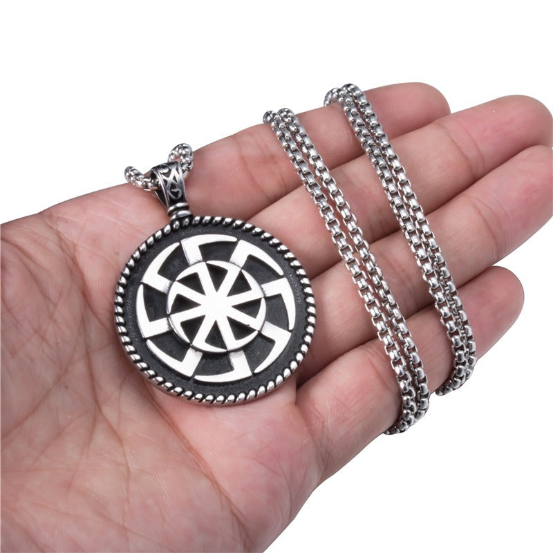 Kolovrat Pagan stainless steel pendant held in hand, showcasing unique Slavic sun symbol and intricate design.