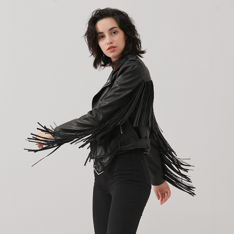 Stylish woman in a cropped black PU leather jacket with fringe and silver fittings, showcasing rock style fashion.
