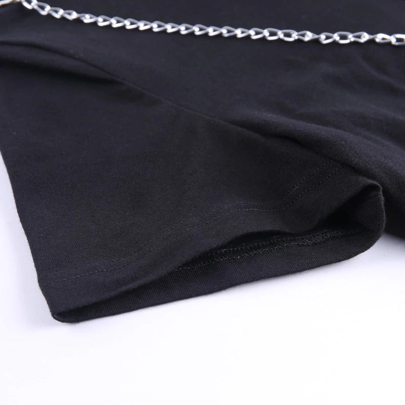 Close-up of black gothic crop top showcasing chain decoration and asymmetrical hem.