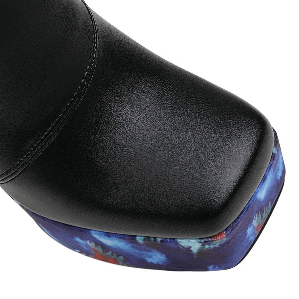 Close-up of stylish ladies' platform square toe boot with a glossy black finish and patterned blue heel.