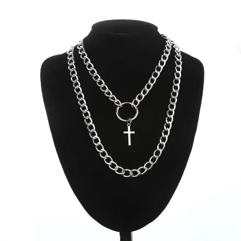 Layered silver chain necklace with cross pendant showcased on a black display, perfect for punk style lovers.