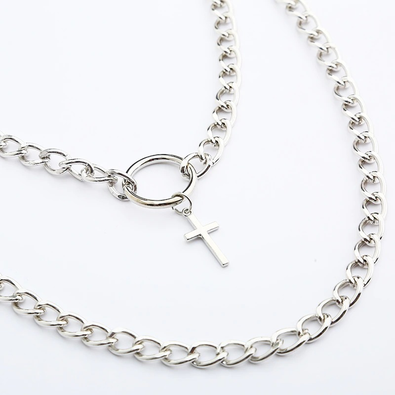 Layered silver chain necklace with cross pendant for punk style fashion. Unisex aesthetic jewelry design.