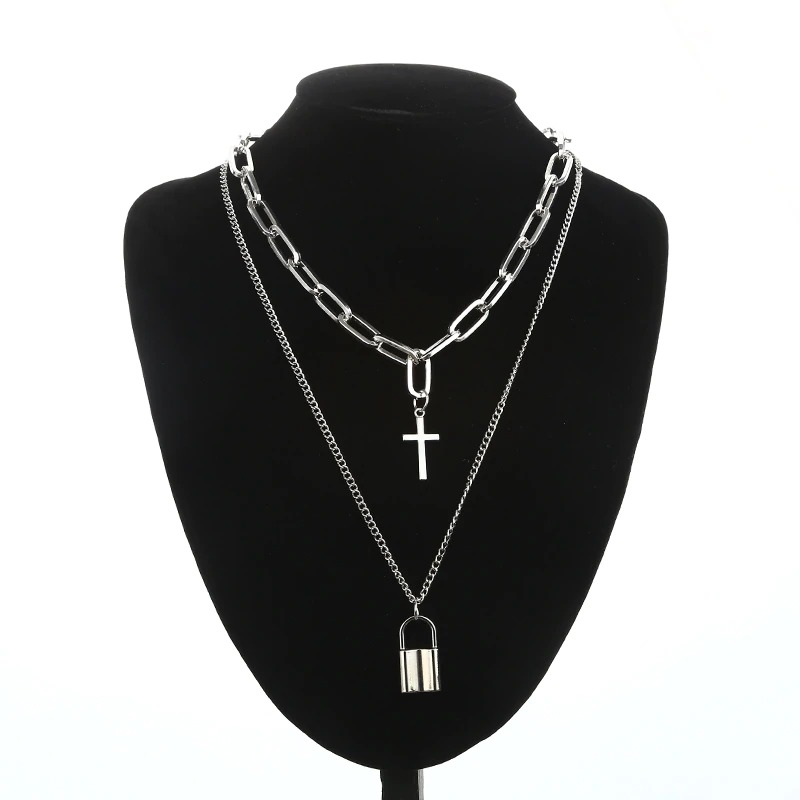 Layered chain necklace in punk style featuring a cross and padlock pendants on a display bust.
