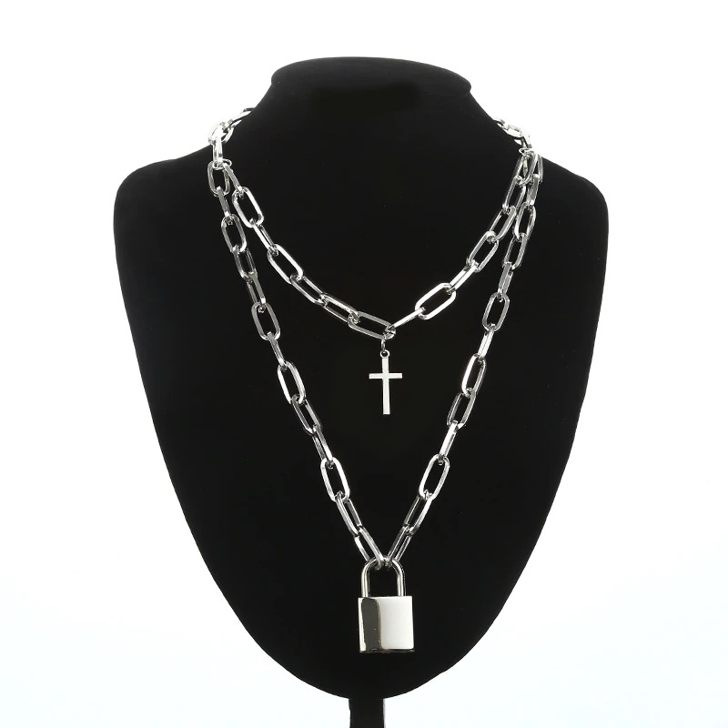 Layered punk-style chain necklace on a black bust, featuring cross and padlock pendants, unisex design.