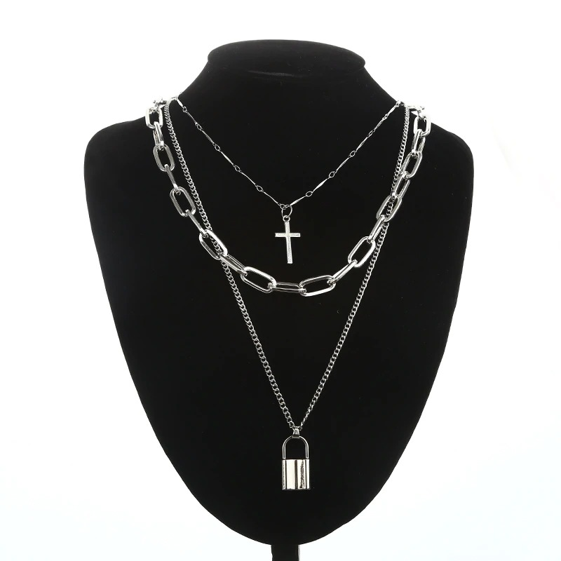 Layered silver chain necklace with cross and lock pendants on a display bust, perfect for unisex punk fashion.