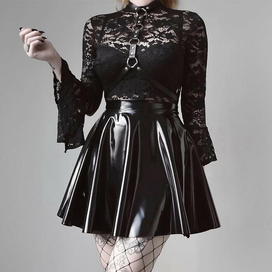 Elegant gothic outfit featuring a lace top and shiny black skirt with a leather harness for a stunning festival look.