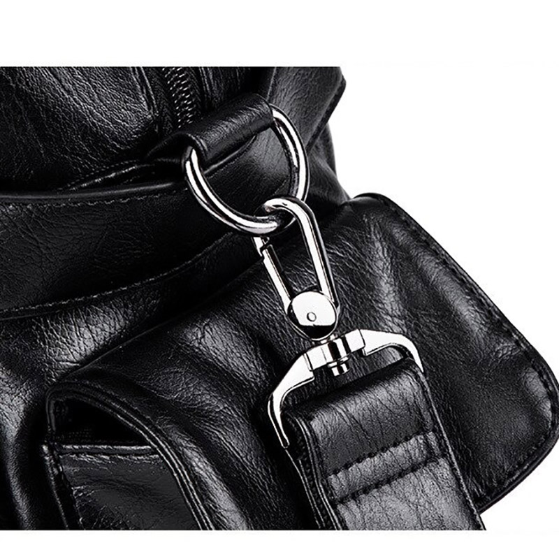 Close-up of a black faux leather handbag strap and metal clip, highlighting gothic style design and functionality.