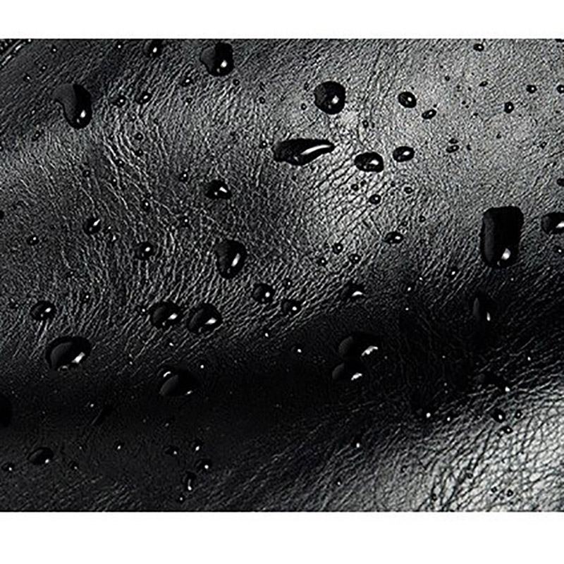 Close-up of black faux leather with water droplets showcasing its water-resistant quality.