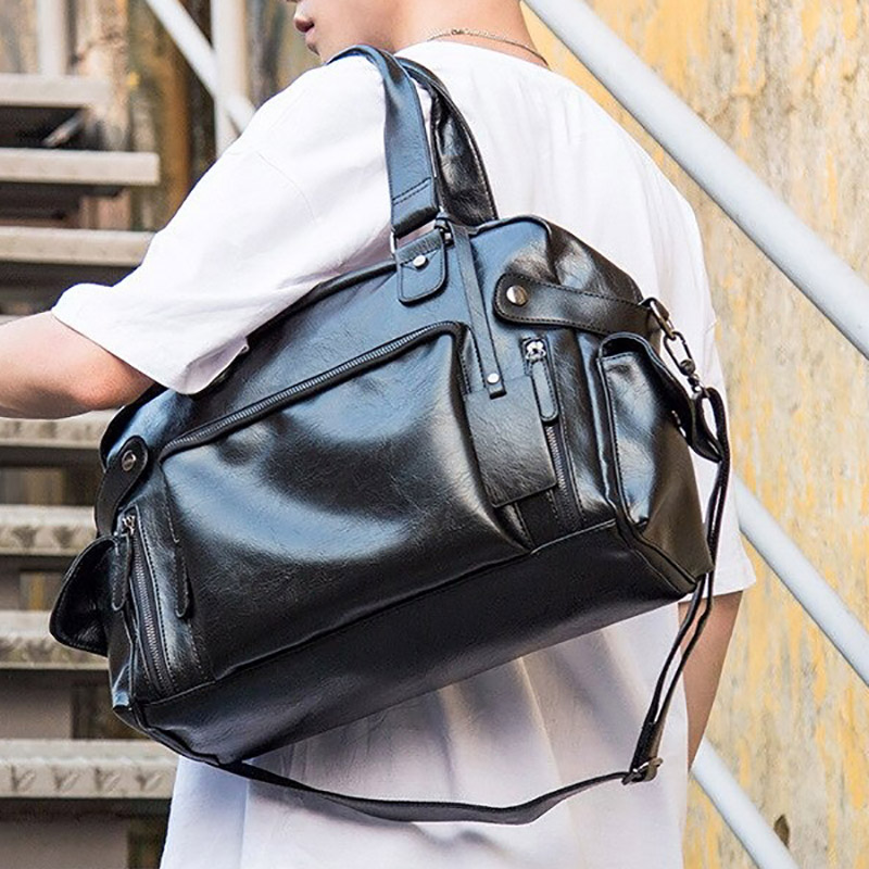 Stylish black faux leather men's messenger bag with multiple pockets, perfect for travel and complementing goth outfits.