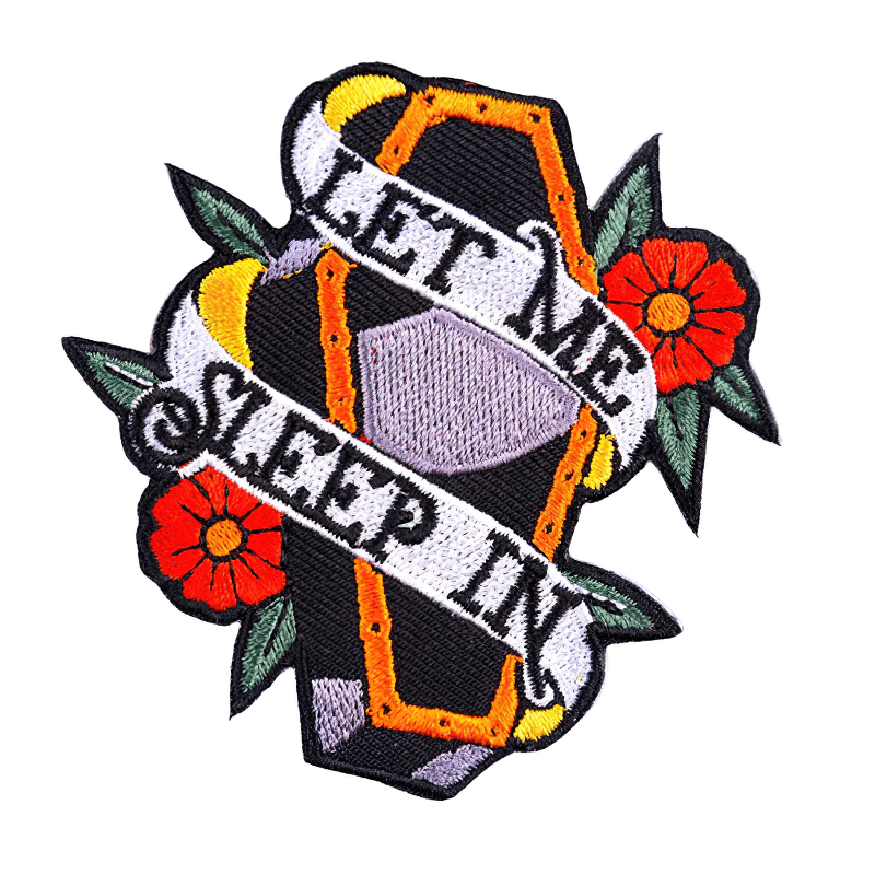 Gothic patch featuring a coffin surrounded by flowers and the phrase 'Let Me Sleep In' for stylish clothing.
