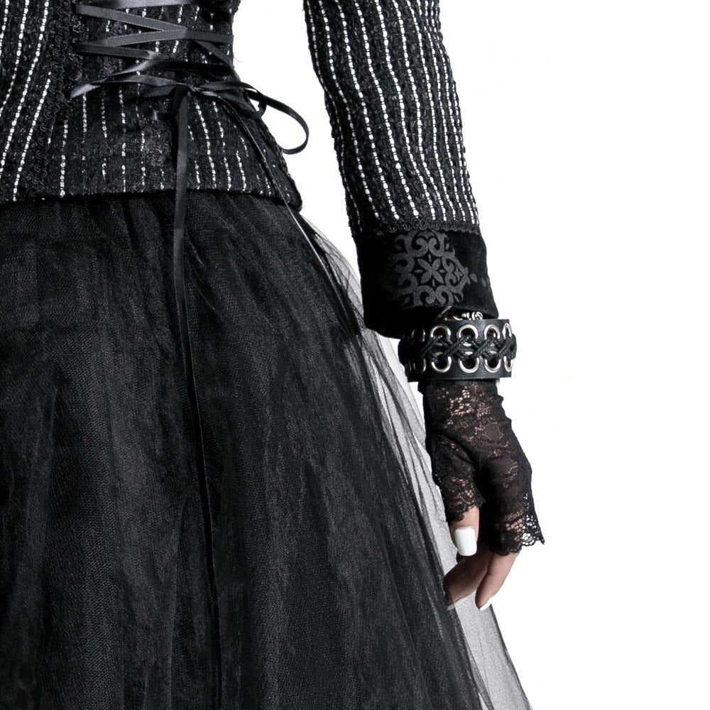 Stylish female in gothic attire wearing lace black gloves and leather bracelets, showcasing a retro-chic look.