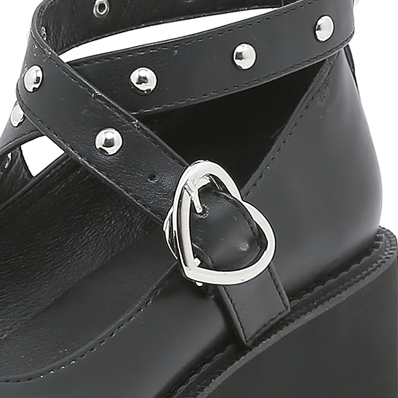 Close-up of black Lolita style shoe with heart buckle and studded straps, perfect for stylish cosplay.