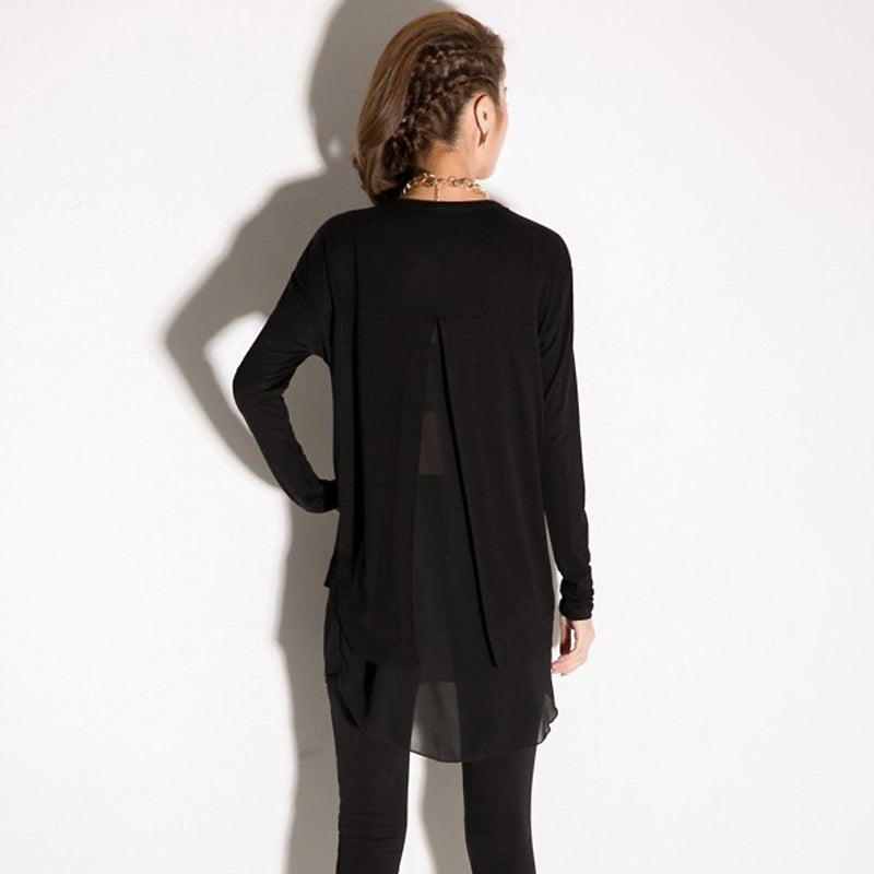 Back view of a woman in a stylish long sleeve black chiffon top with a loose fit and unique design.
