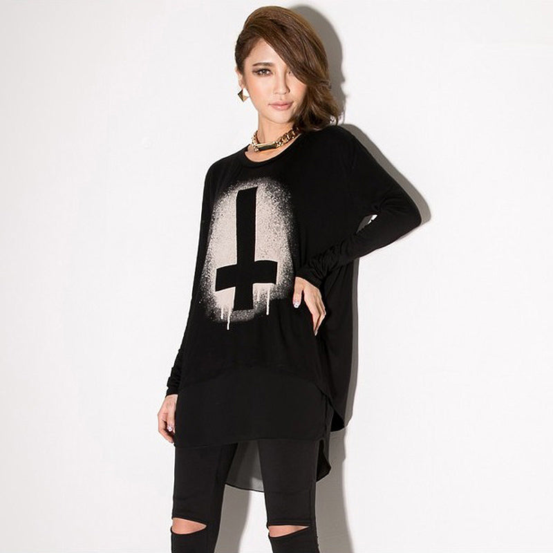 Stylish woman in a black long sleeve gothic sweater with bold print, paired with black leggings for a chic look.