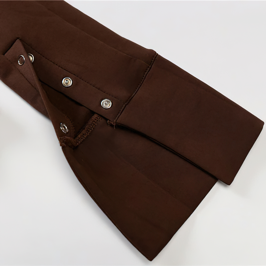 Close-up of the button detail on the sleeve of a brown long sleeve one-piece romper for women.