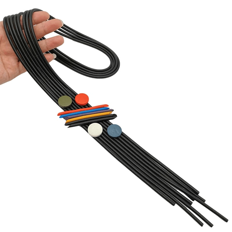 Hand holding a long black rubber necklace with colorful pendant accents, showcasing trendy gothic style.