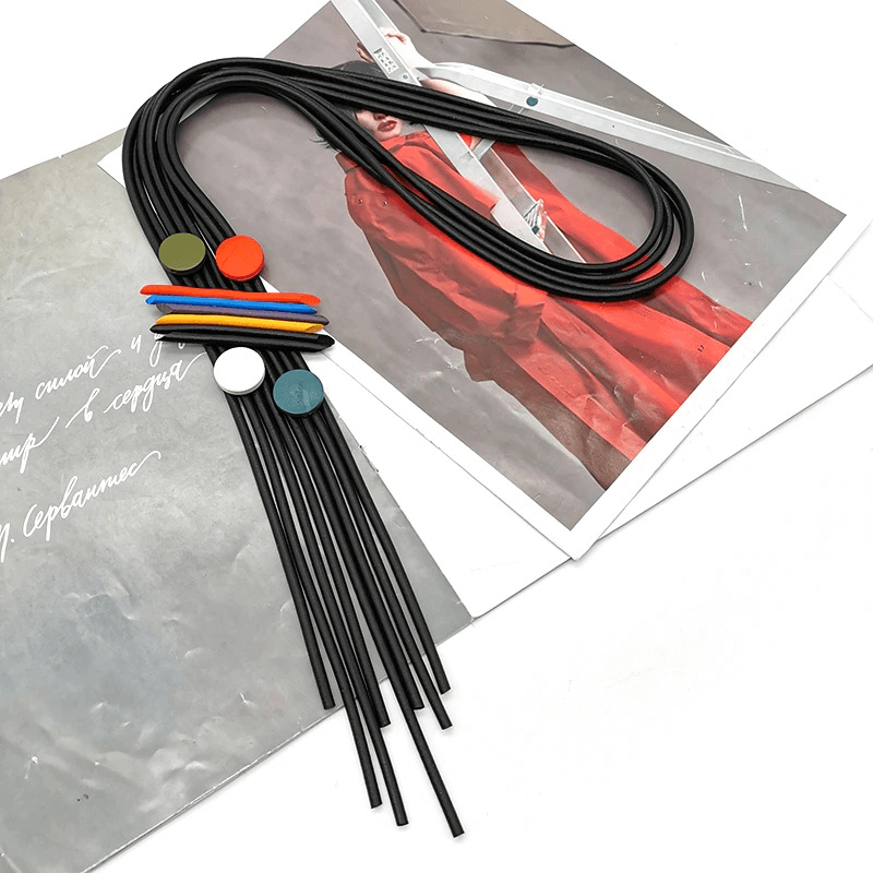 Stylish long tassel necklace for women, featuring luxury rubber pendant and colorful inserts on a chic backdrop.