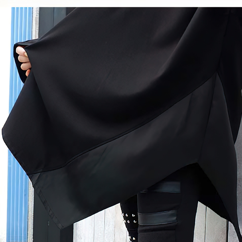 Close-up of black oversized sweatshirt's asymmetrical hem, showcasing stylish design and casual look.