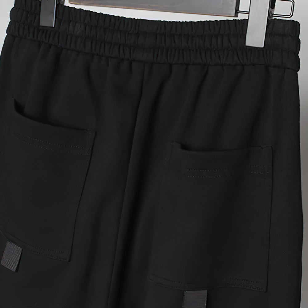 Close-up of black men's pants with elastic waist and multi pockets, perfect for casual everyday wear.